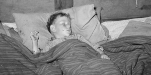 Sick child sleeping in trailer home near Sebastian, Texas. Lee Russell, 1939